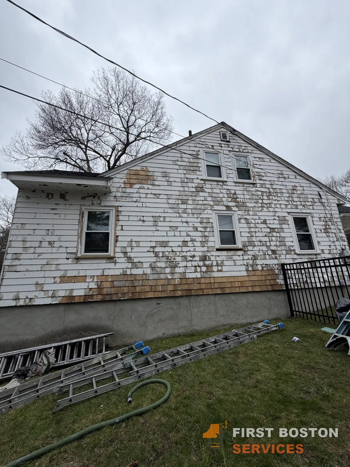 First Boston Services: Rear wall before, paint failing across the siding